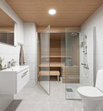Kylpyhuone jossa WC-istuin ja suihku oikealla, sauna tilan perällä ja käsienpesuallas vasemmalla.